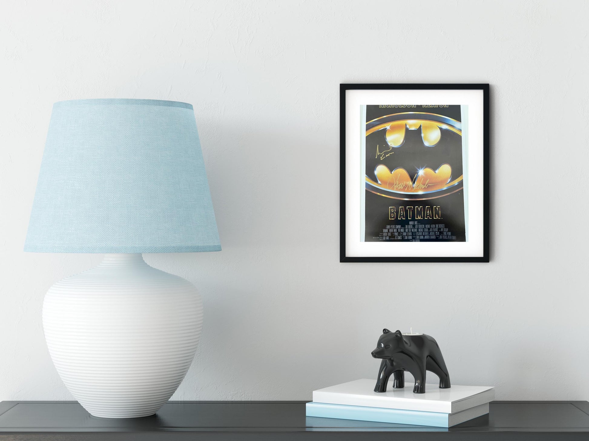 a picture of a batman poster on a wall next to a lamp